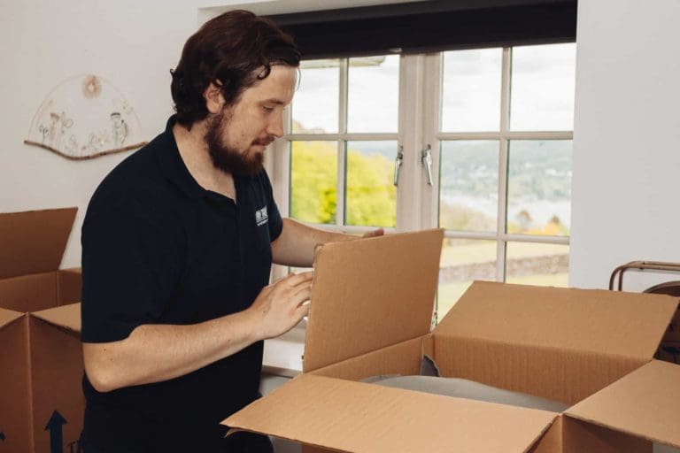 A guy is closing the big storage box with all things to store