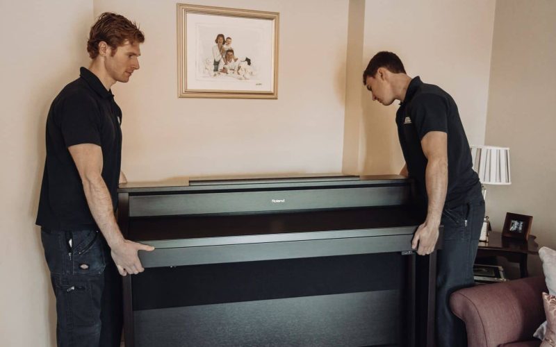 Roy Trevor team moving a piano