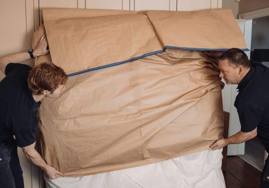 roy trevor team packing large item for export